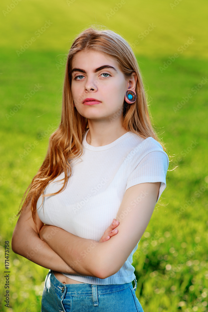 Portrait of a young beautiful woman with wooden tunnels in her ears Portrait of a young beautiful woman with wooden tunnels in her ears