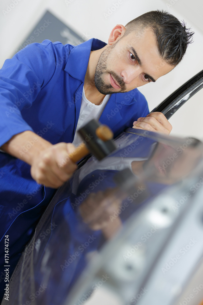 coachbuilding student working on automobile in garage