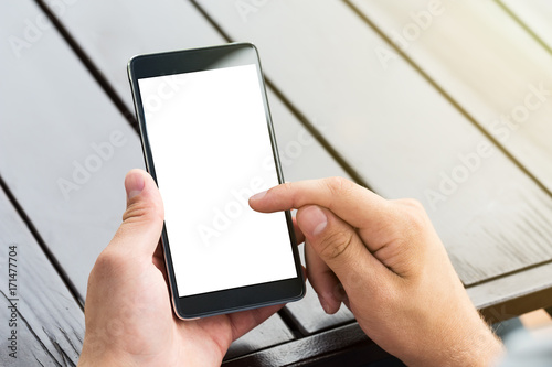 Man holding smart mobile phone on wooden table background