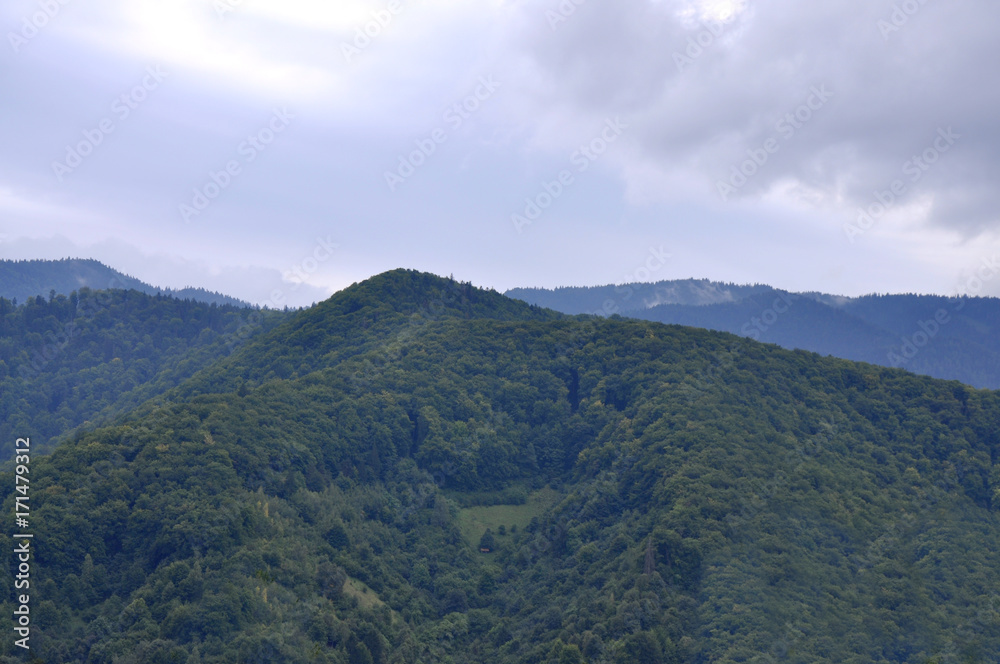 Big green mountain with clouds