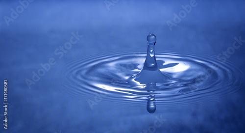 Water drop falling into water