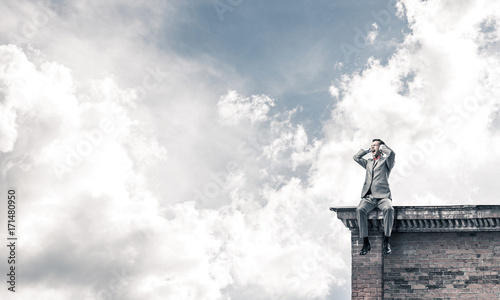 Young man on building roof dont want to hear anything