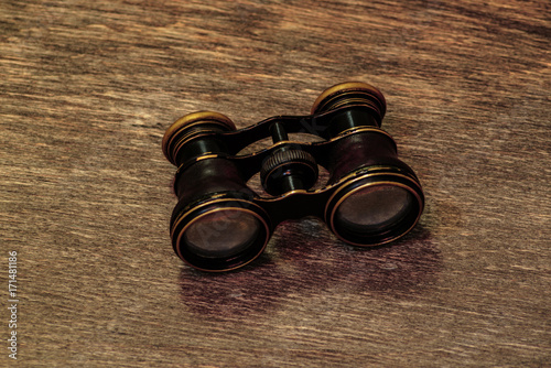 Old binoculars on a wooden background