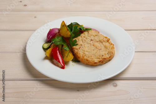 Fish cutlet with grilled potato, onion, pepper and zucchini