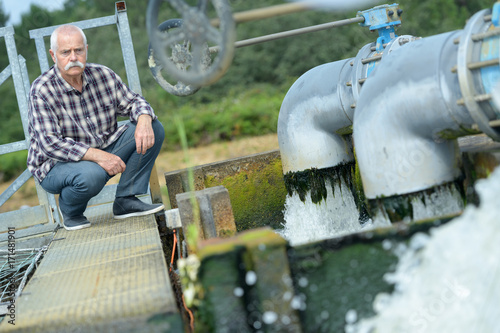 a workman inspecting a dam photo