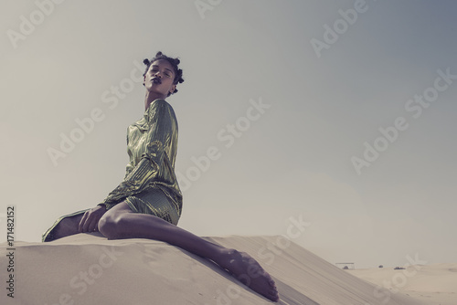 Black model sitting on Sand Dune