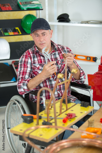 manual worker in wheelchair doing plumbery