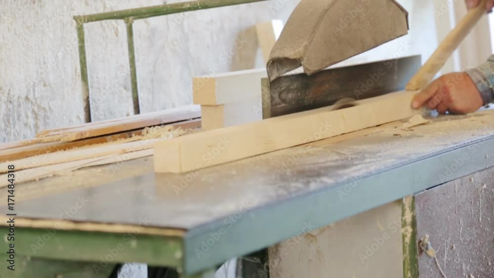 Sawing the wooden square beam on circular saw Sawing the wooden square beam on circular saw