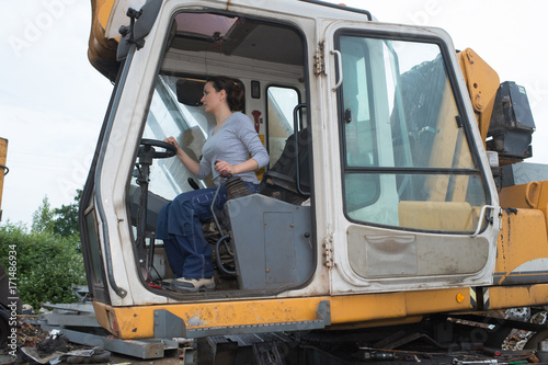 brunette woman is operating a tractor