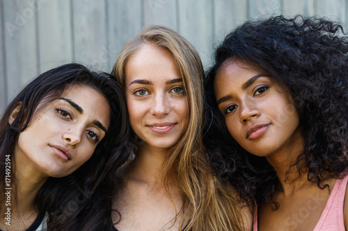 Close up portrait of three young women, looking at camera