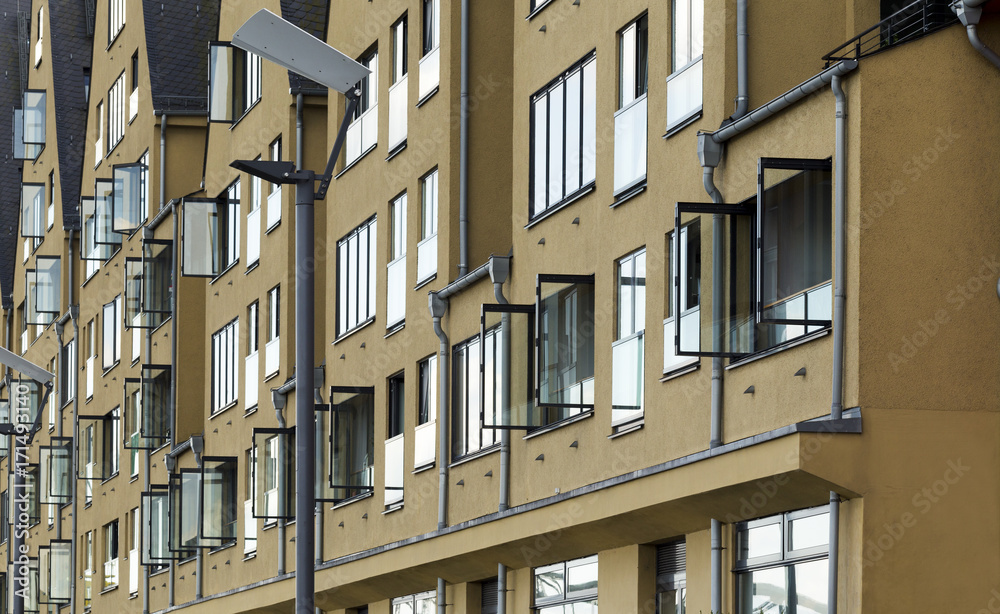 Modern building facade in Cologne, Germany. House with windows reflecting sky