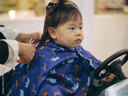 Asian baby girl do hair cut first time in hairdressing shop