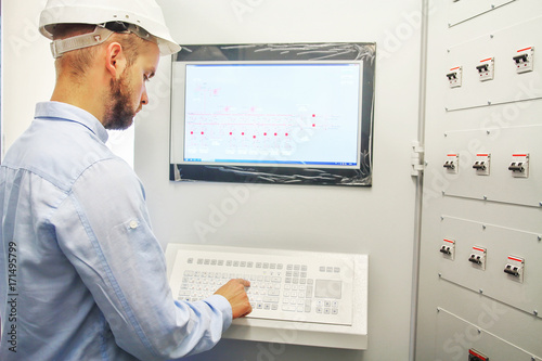 engineer controls technological equipment from remote control board. Scada system for automation equipment
