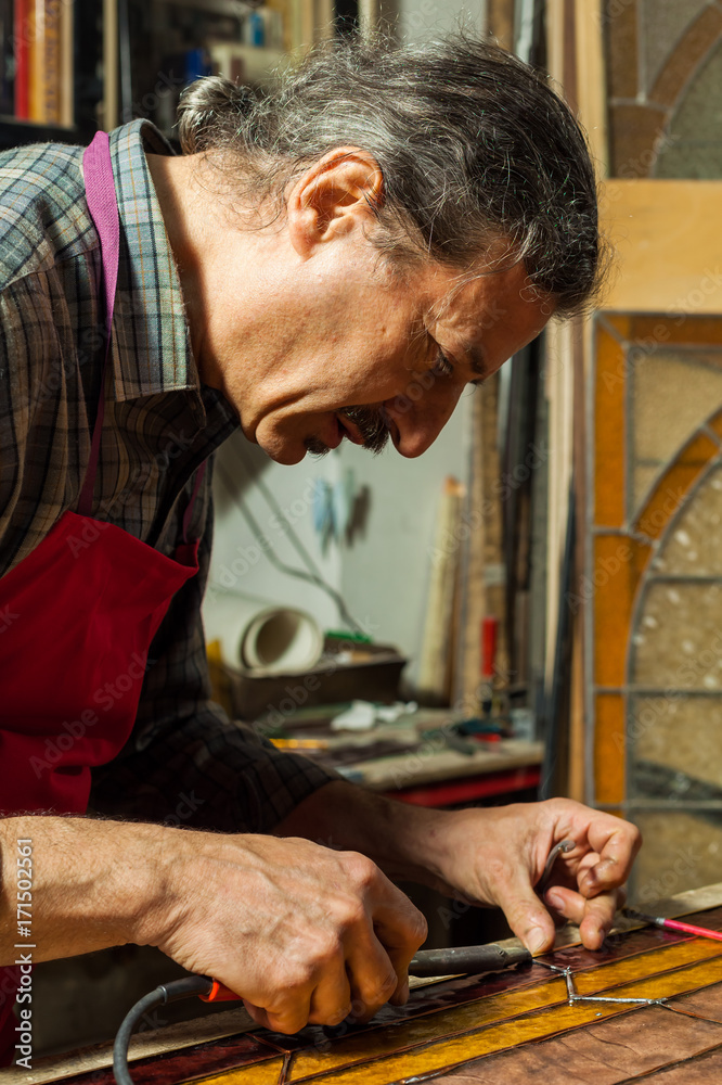 Artisan making Stained Glass panels in his Workshop Artisan making Stained Glass panels in his Workshop