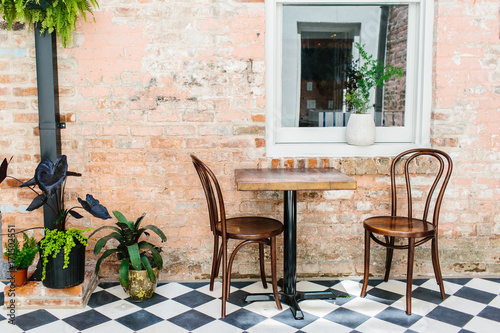 A lounge area with seating / checkered floor & vintage brick walls. photo