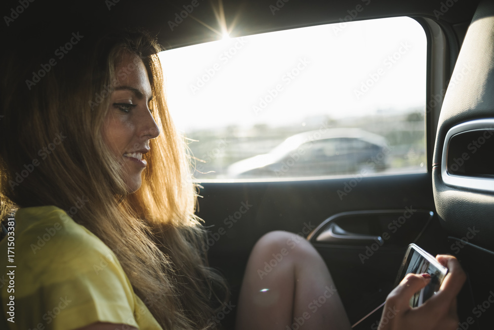 Close-up of young woman using a mobile phone while sitting in the car Close-up of young woman using a mobile phone while sitting in the car