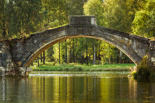 Autumn landscape with old stone hump-back bridge in Gatchina. Russia