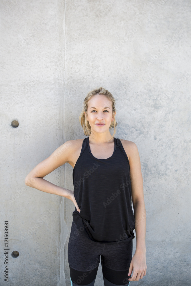 Woman leaning against a wall looking into the camera Woman leaning against a wall looking into the camera