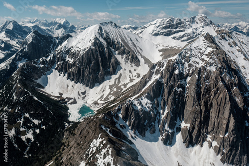 Vivid blue glacial lake at the bottom of a mountain photo