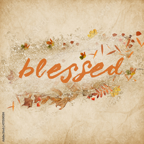 word blessed in autumn leaves and acorns on textured background