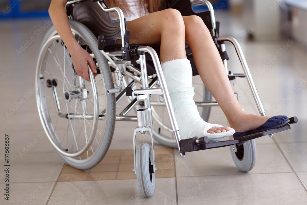Obraz premium A young girl in a wheelchair is standing in the corridor of the hospital.