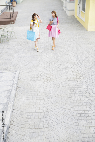 Two women smiling with shopping bags photo