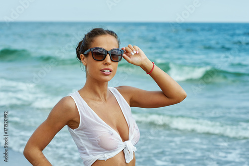 Young female model in summer white blouse on the seaside . The concept of summer vacation and travel