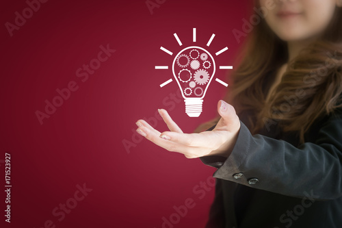 Asian Business girl hand presenting with light bulb as idea or creative concept.
