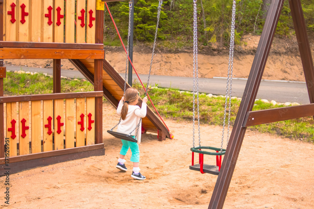 go on the swings. Kid playing on a swing set. Public child's swingset