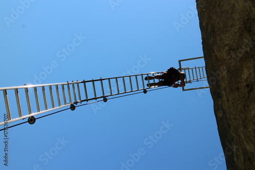 Climber on ladder in via ferrata Trattenbacher Klettersteig - Beisteinmauer, Austria  photo