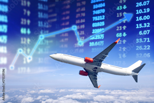 Travel business stock market chart, Stock market data with plane above the cloud and stock market board display