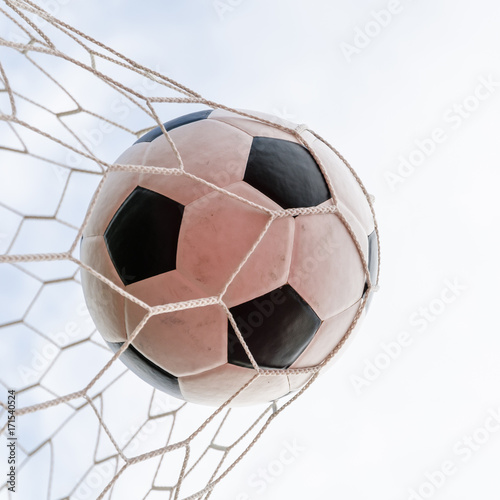 Soccer football in Goal net with the sky field.