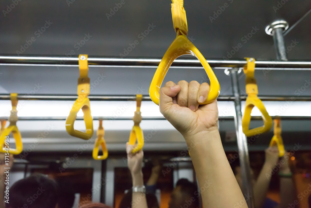 woman hand holding onto a handle of bus (blur background)
