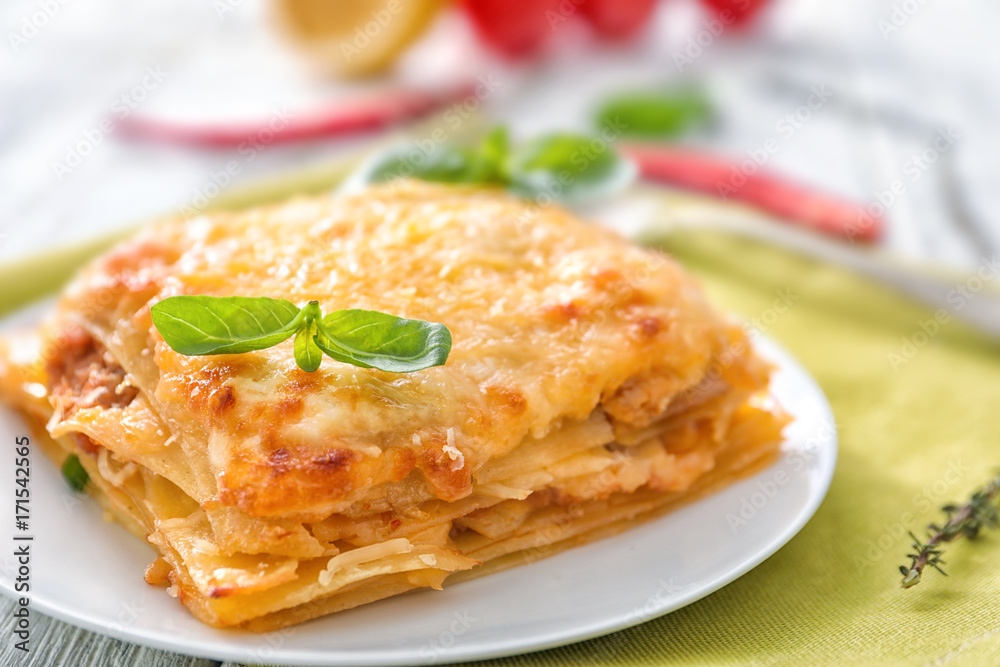 Plate with tasty lasagna on table