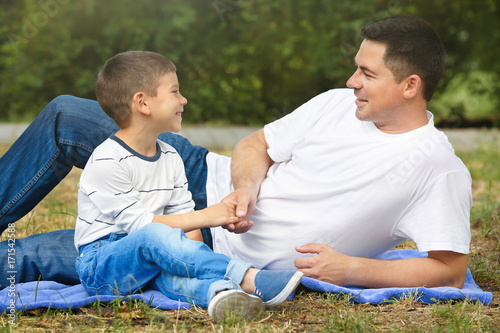 Happy father and son resting in park © Africa Studio