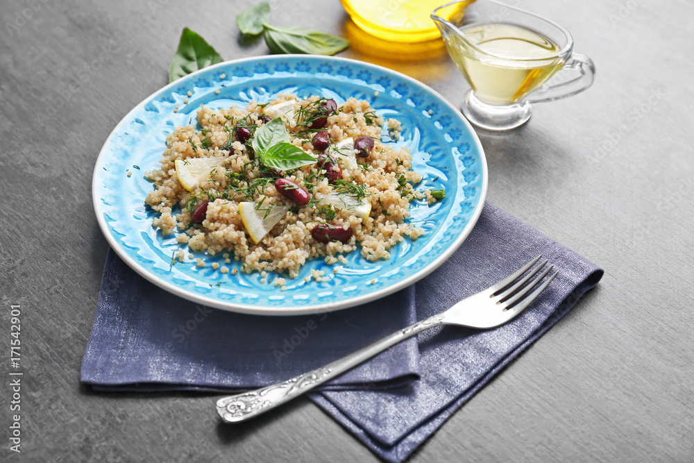 Salad with quinoa, basil and beans served on grey background