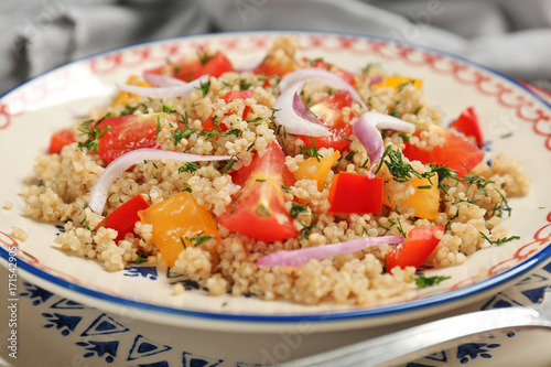 Salad with quinoa, tomatoes and onion on plate, closeup