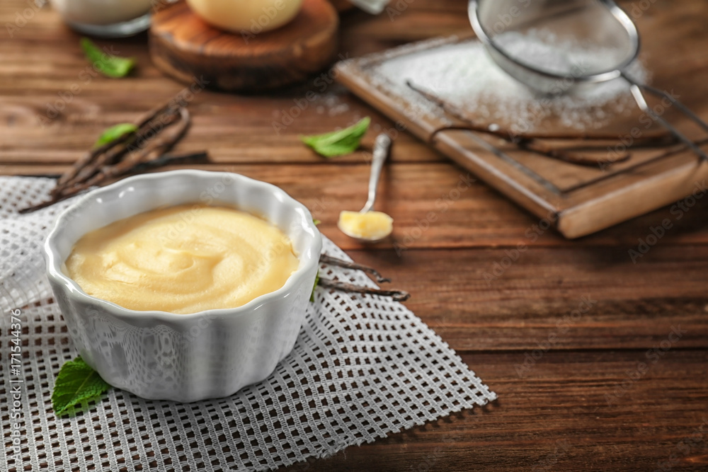 Vanilla pudding in ceramic bowl on wooden table Vanilla pudding in ceramic bowl on wooden table
