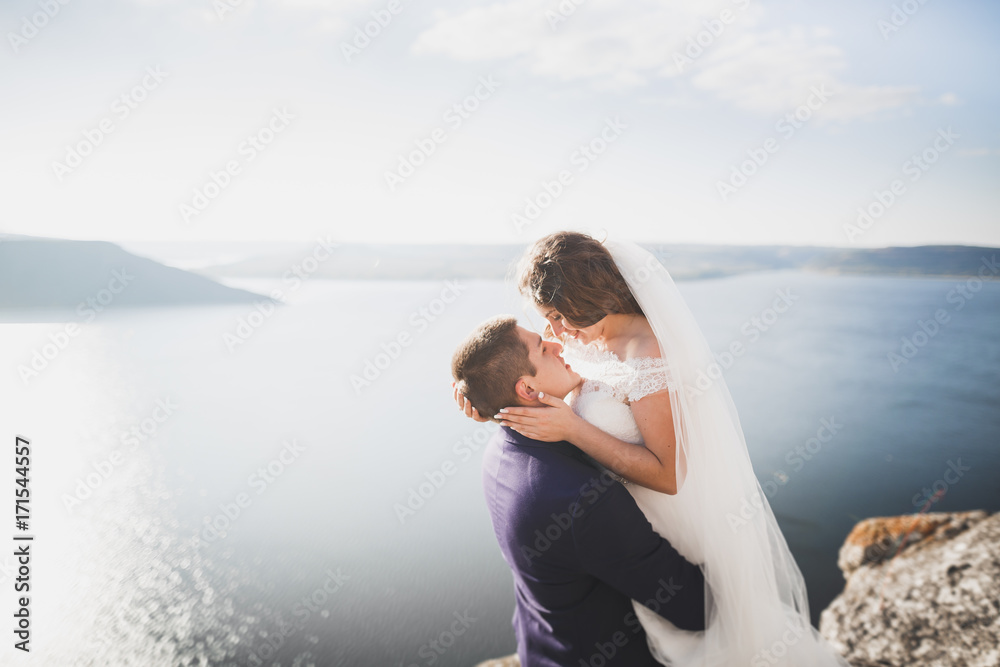 Happy and romantic scene of just married young wedding couple posing on beautiful beach Happy and romantic scene of just married young wedding couple posing on beautiful beach