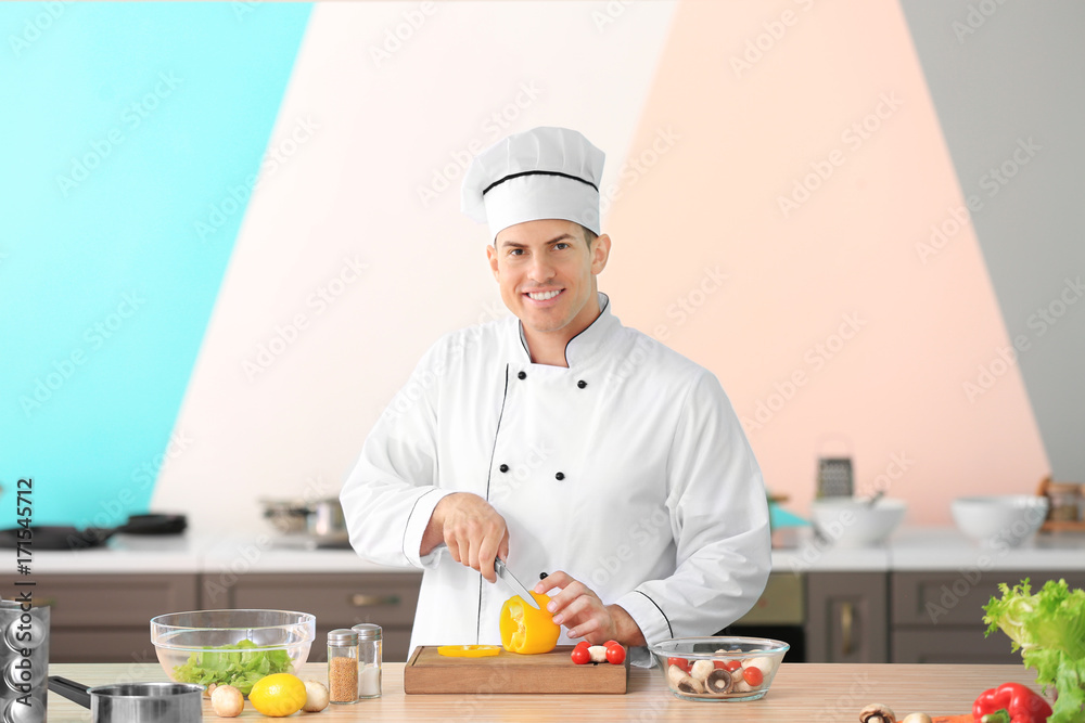 Young male chef cooking in kitchen