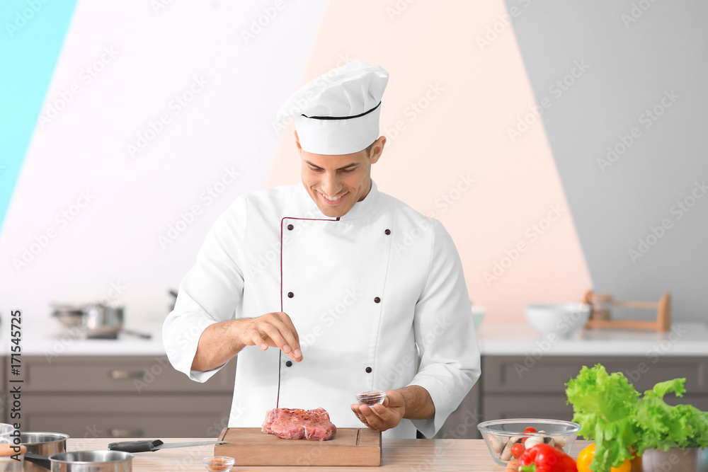 Young male chef cooking meat in kitchen Young male chef cooking meat in kitchen