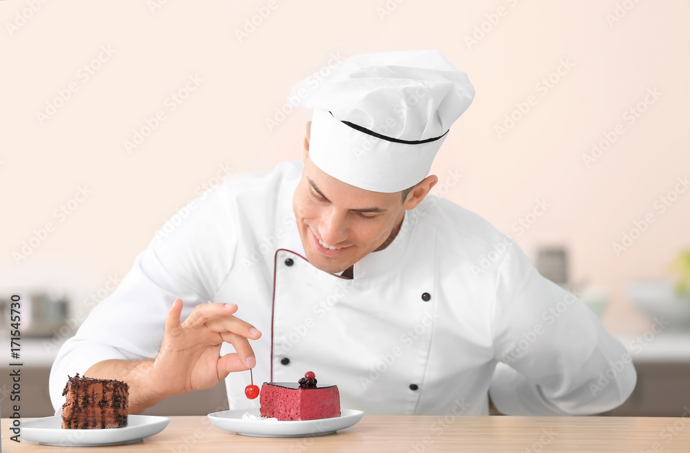 Young male chef decorating tasty dessert in kitchen Young male chef decorating tasty dessert in kitchen