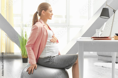Young pregnant woman working in home office