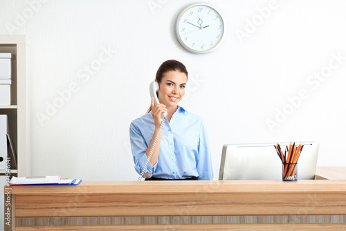 Young female receptionist working in office
