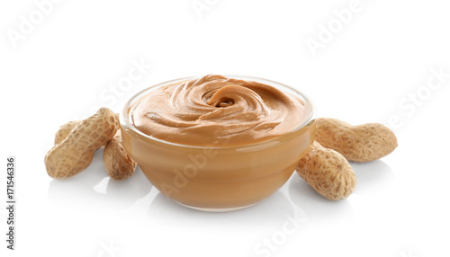 Glass bowl with creamy peanut butter on white background
