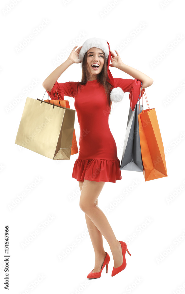 Young woman in Santa hat holding colorful shopping bags on white background. Boxing day concept