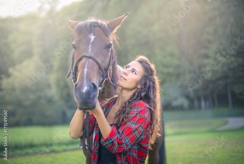 Cute girl stroking her horse