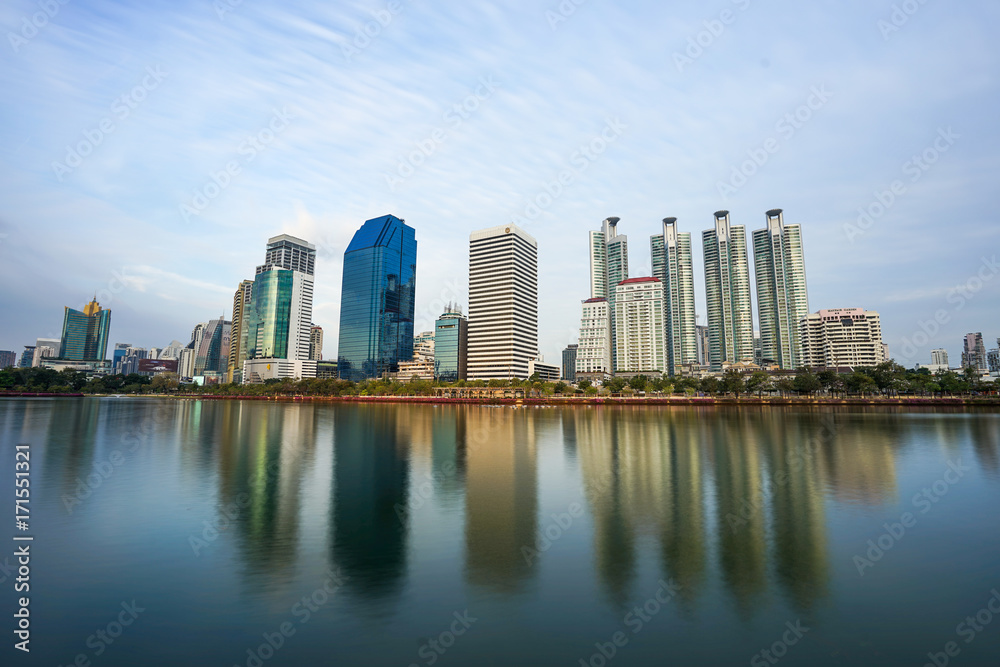 Fototapeta premium Asoke modern buildings of Bangkok night city skyline, Thailand. Cityscape photography of Benchakitti Park at dusk. Bangkok night city downtown. Modern night city skyline with lights reflection, Asia