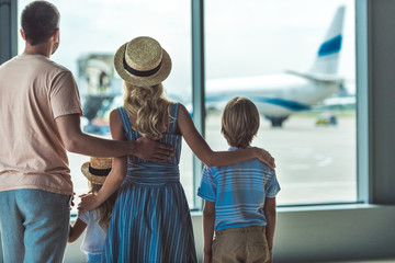 family looking out window in airport