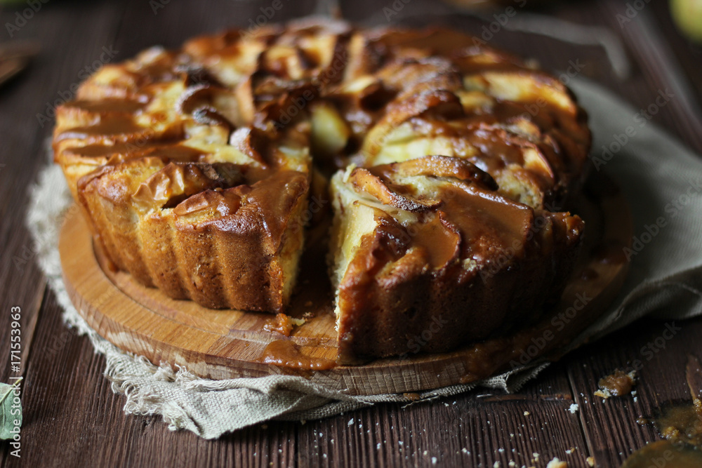 Apple pie with salted caramel on a wooden background